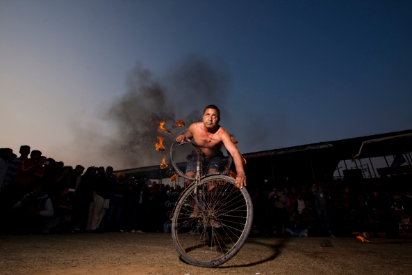Acrobat Passing Bicycle through Burning tyre. 